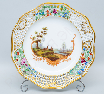 Тарелка из «Охотничьего сервиза» с ажурным бортом с лепными цветами и изображением оленей на зеркале. Императорский фарфоровый завод